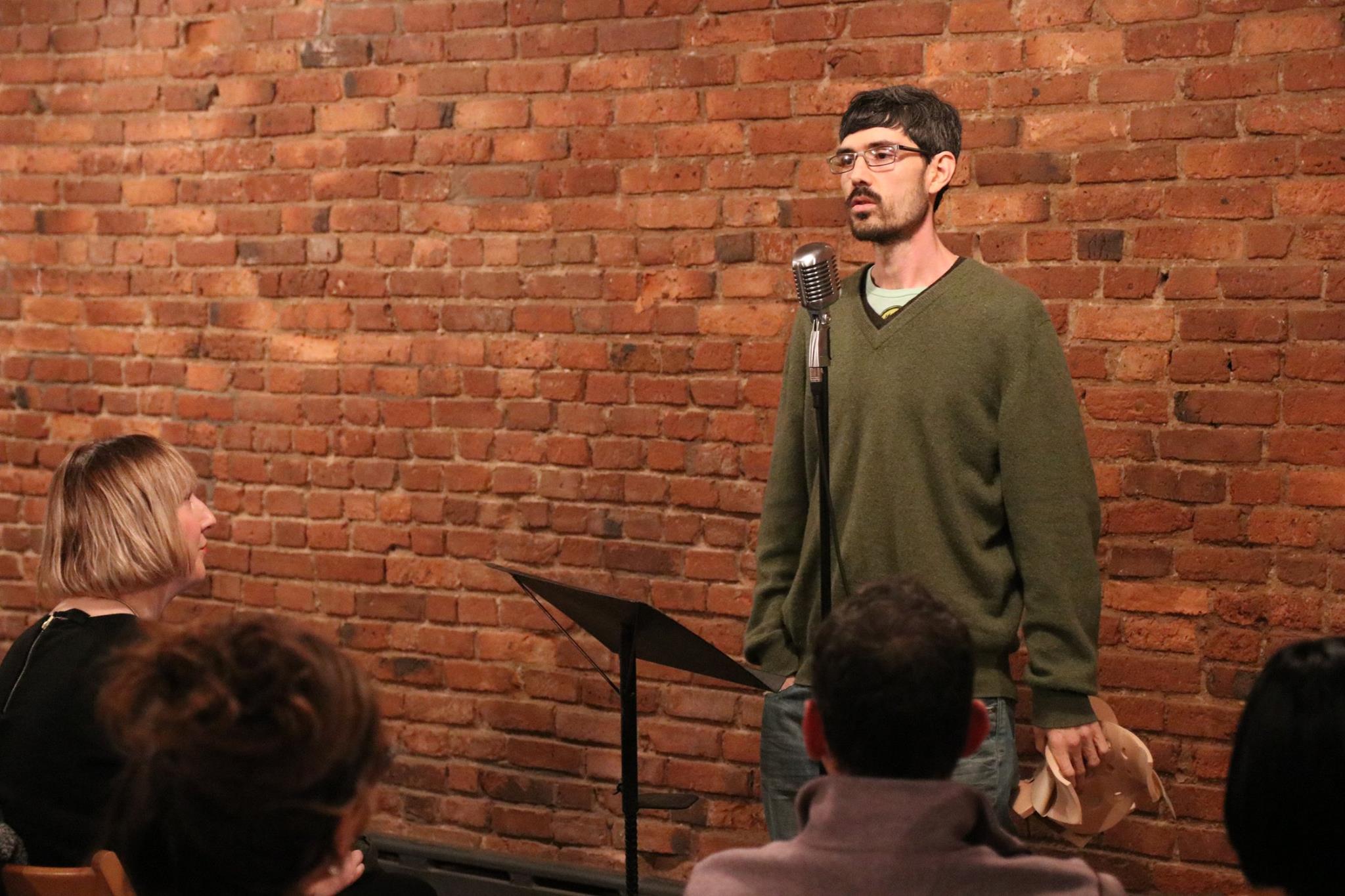 Ricky Ray reading poetry at a microphone